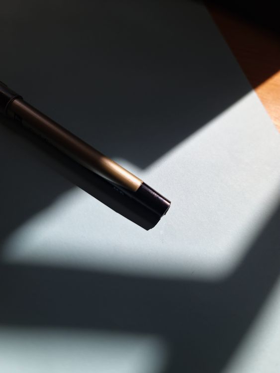 Shadow Using Pen Pen on a Desk in Shadow · Free Stock Photo