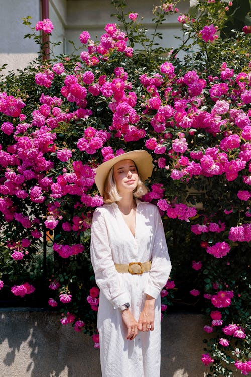 Blonde Woman Posing among Pink Flowers