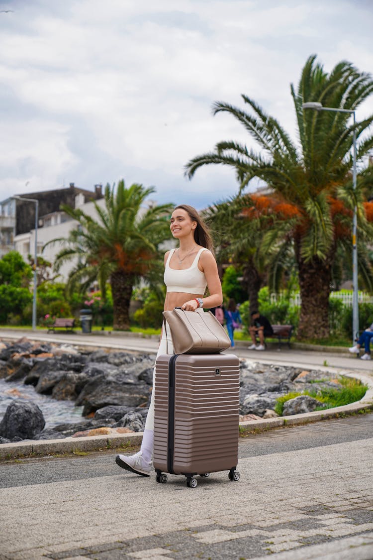 Woman In Sportswear Walking With A Suitcase 