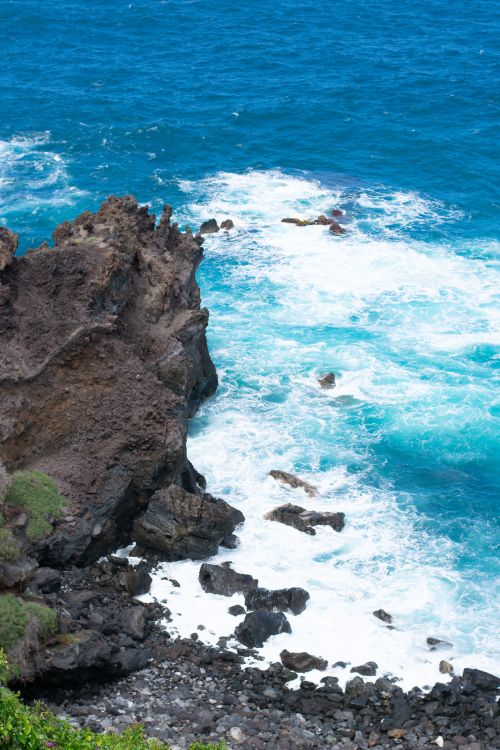 Free High-angle view of waves crashing against a rocky coastline, creating a dramatic seascape. Stock Photo