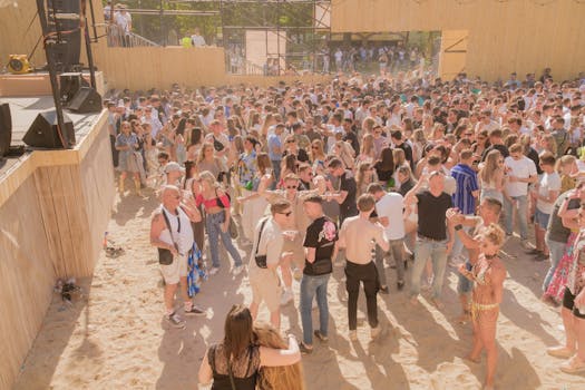 Large gathering enjoying a sunny outdoor music festival by the beach. Perfect summer vibes.
