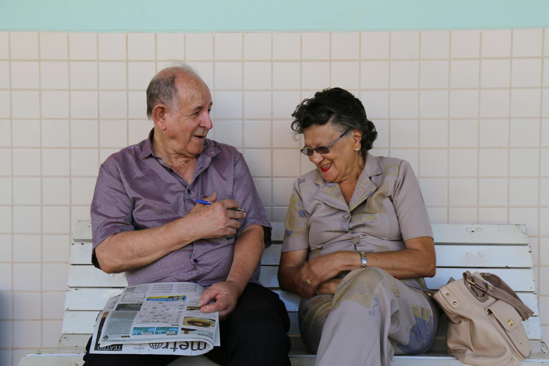 Elderly Couple Sitting on Bench Laughing