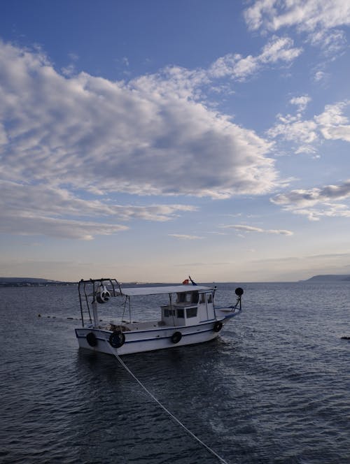 A boat is docked in the ocean with a rope