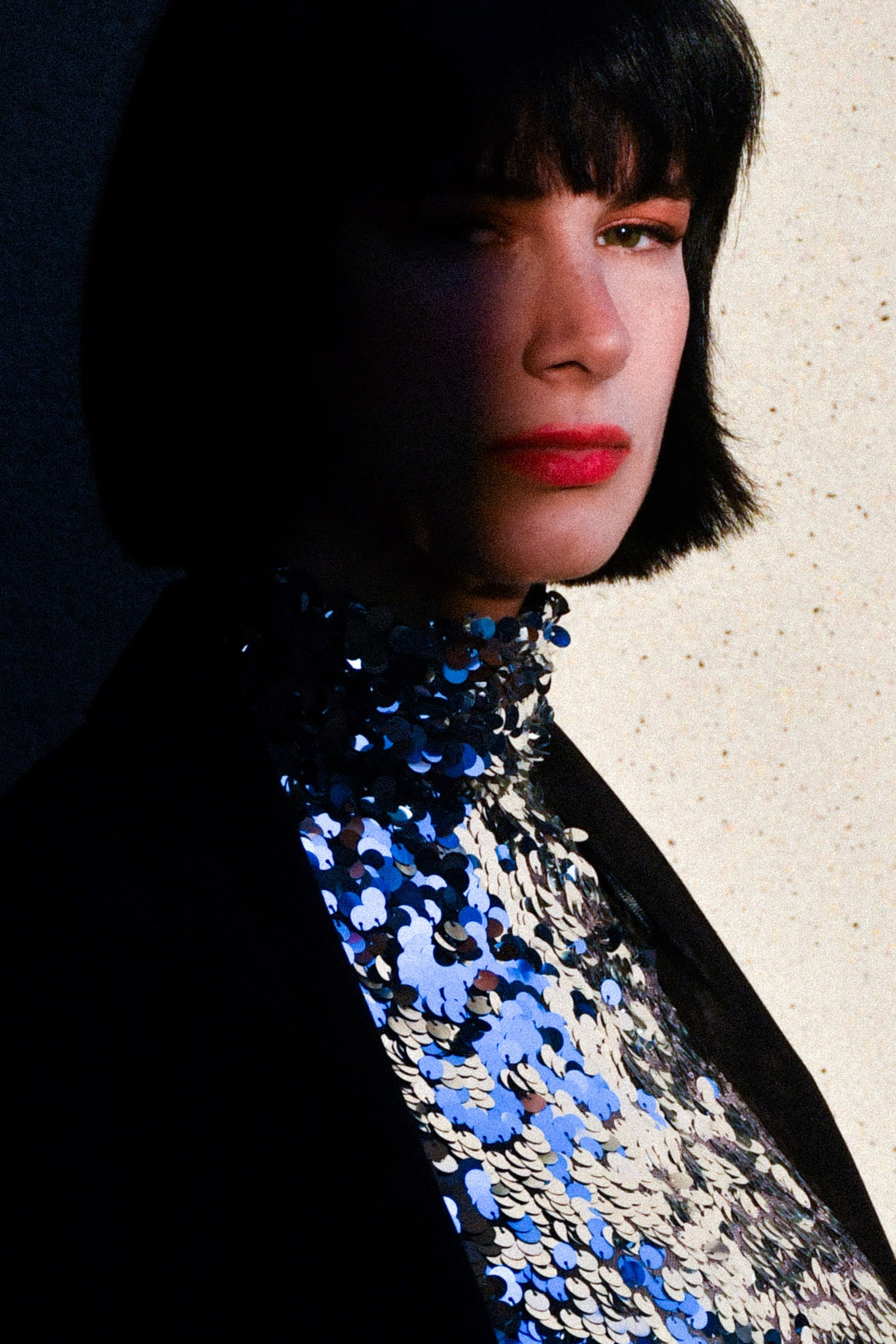 Artistic portrait of a woman in a sequin top with dramatic shadow, İstanbul.