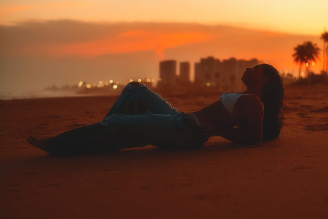 A Woman Posing on the Beach at Sunset · Free Stock Photo