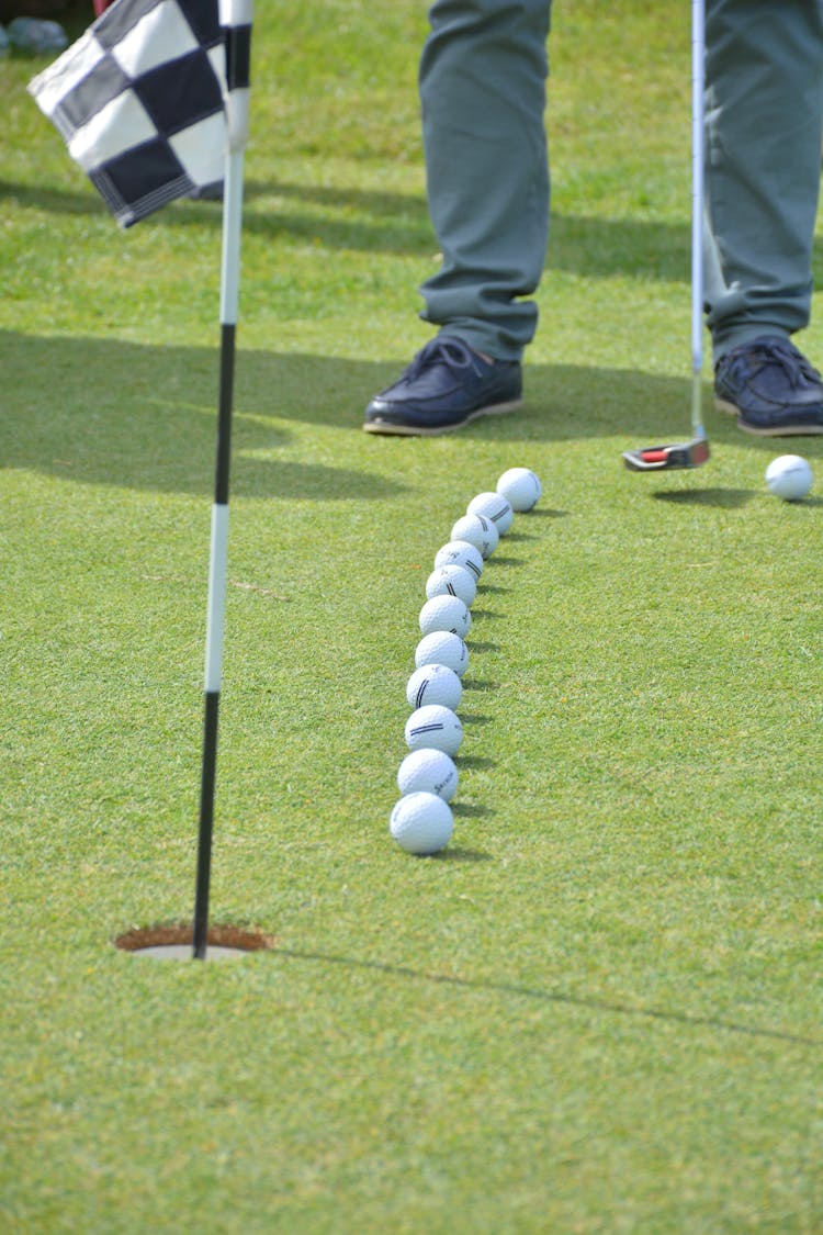 Golfer At The Row Of Balls On The Golf Course