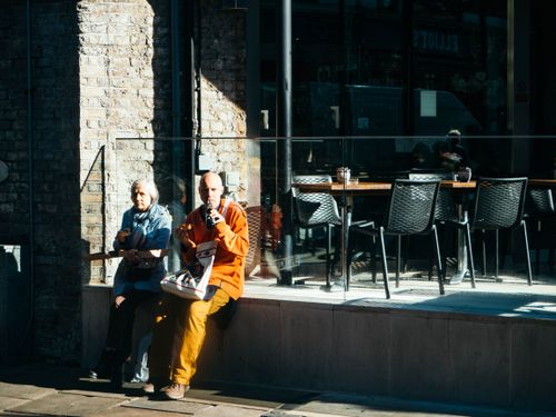 Free A mature couple enjoying a moment together on a sunny day outside a cafe in the city. Stock Photo