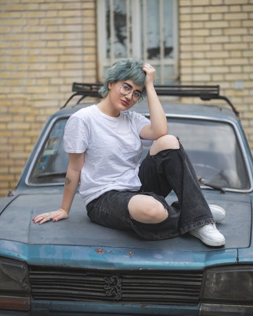 Woman in T-shirt Sitting on Vintage Car