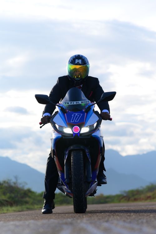 Free Motorcyclist in helmet rides Yamaha on open road with mountain backdrop. Stock Photo