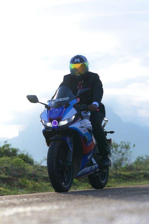Free A motorcyclist in a suit rides his Yamaha sport bike along a scenic road. Stock Photo