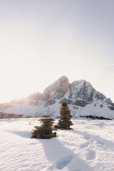 日出时分，白雪覆盖的山脉与堆叠的岩石构成了一幅宁静的冬季景观