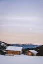 雪山乡村小屋在宁静的冬夜月光下，是静谧的冬季度假胜地