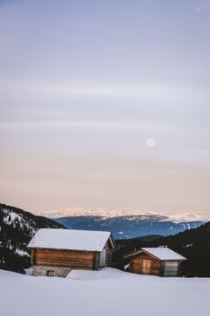 雪山乡村小屋在宁静的冬夜月光下，是静谧的冬季度假胜地