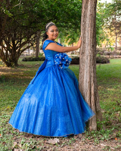 Model in a Blue Evening Dress and Tiara in the Park
