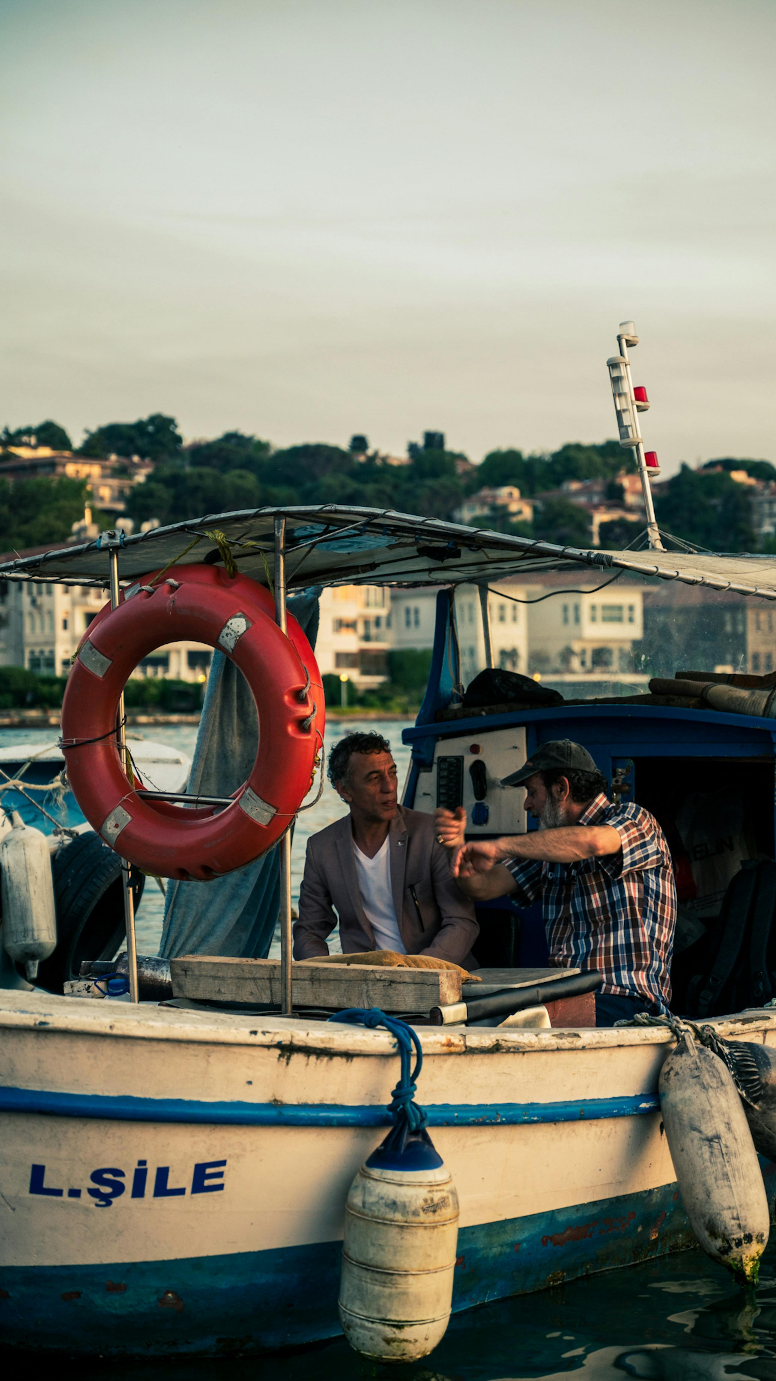Men Sitting on Old Fishing Boat in Water · Free Stock Photo