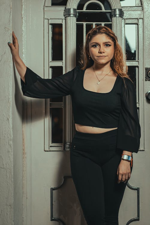 Young Woman in a Black Outfit Posing Outside of a Building 