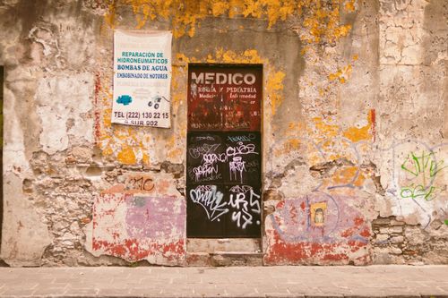 Free A weathered urban wall with graffiti and posters, showcasing artistic decay. Stock Photo