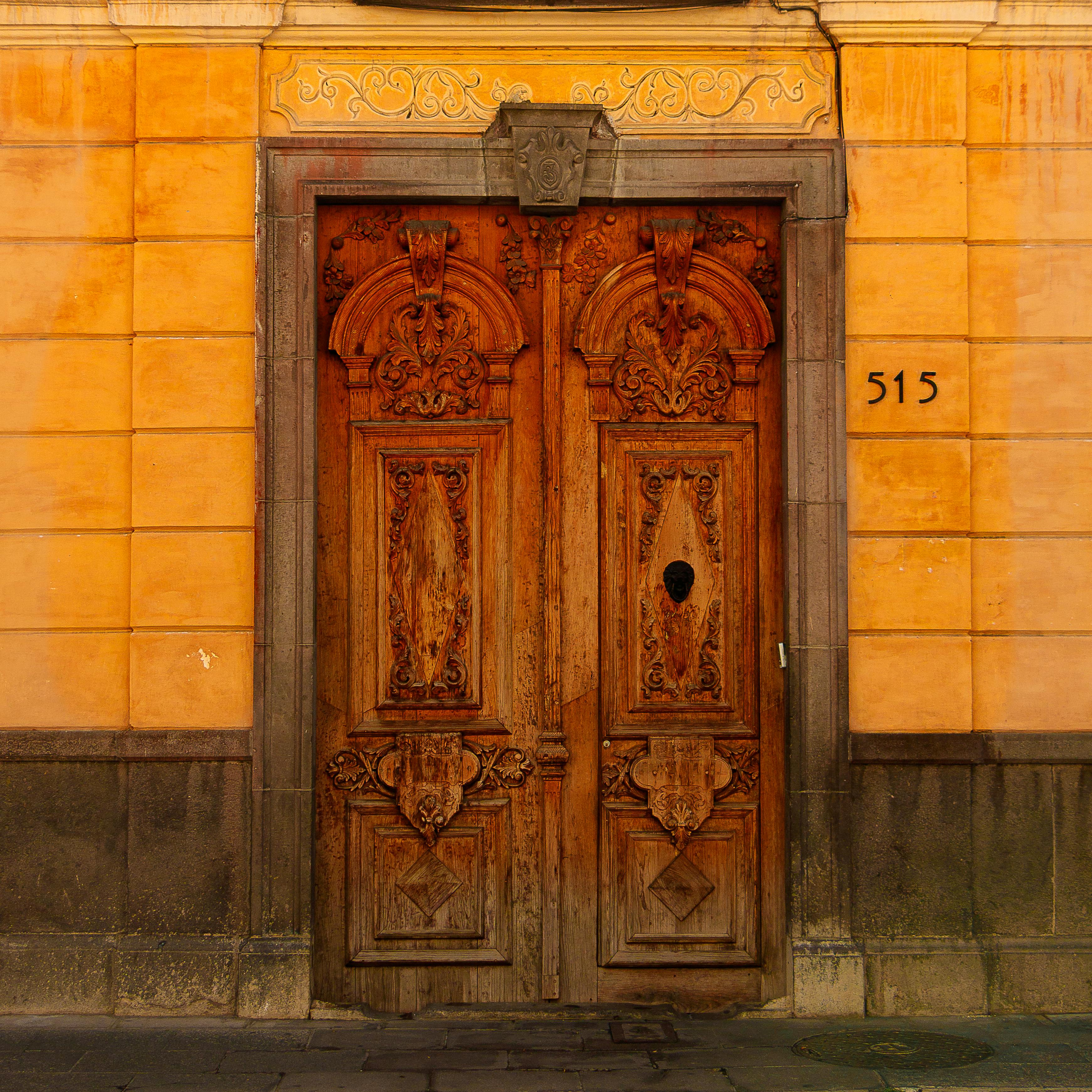 Intricately carved wooden door with decorative facade at entrance number 515.
