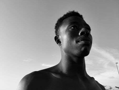 Free Black and white portrait of a young man looking serious under summer sunlight. Stock Photo