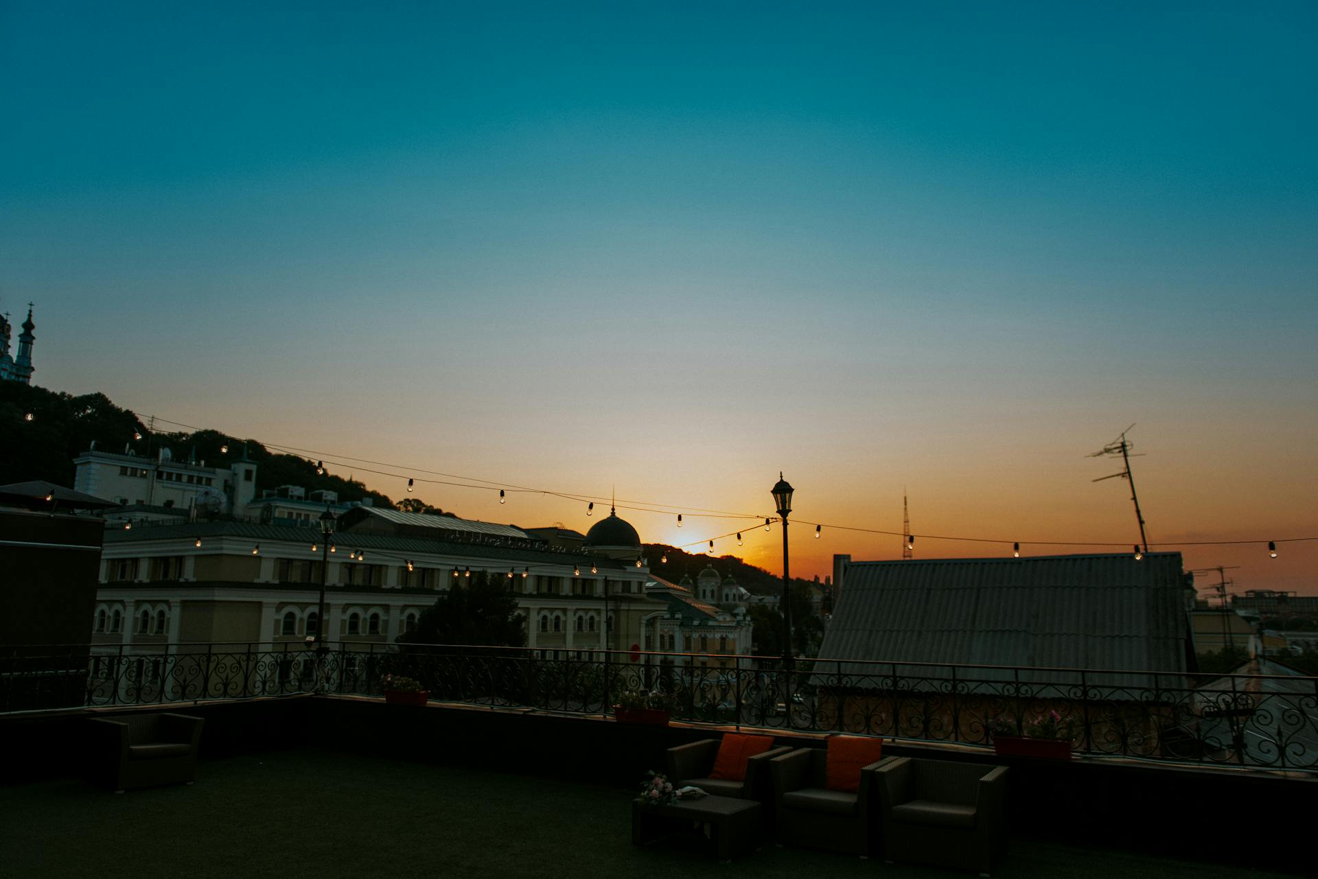 Charming city rooftop lounge view at sunset, perfect ambiance for relaxation.