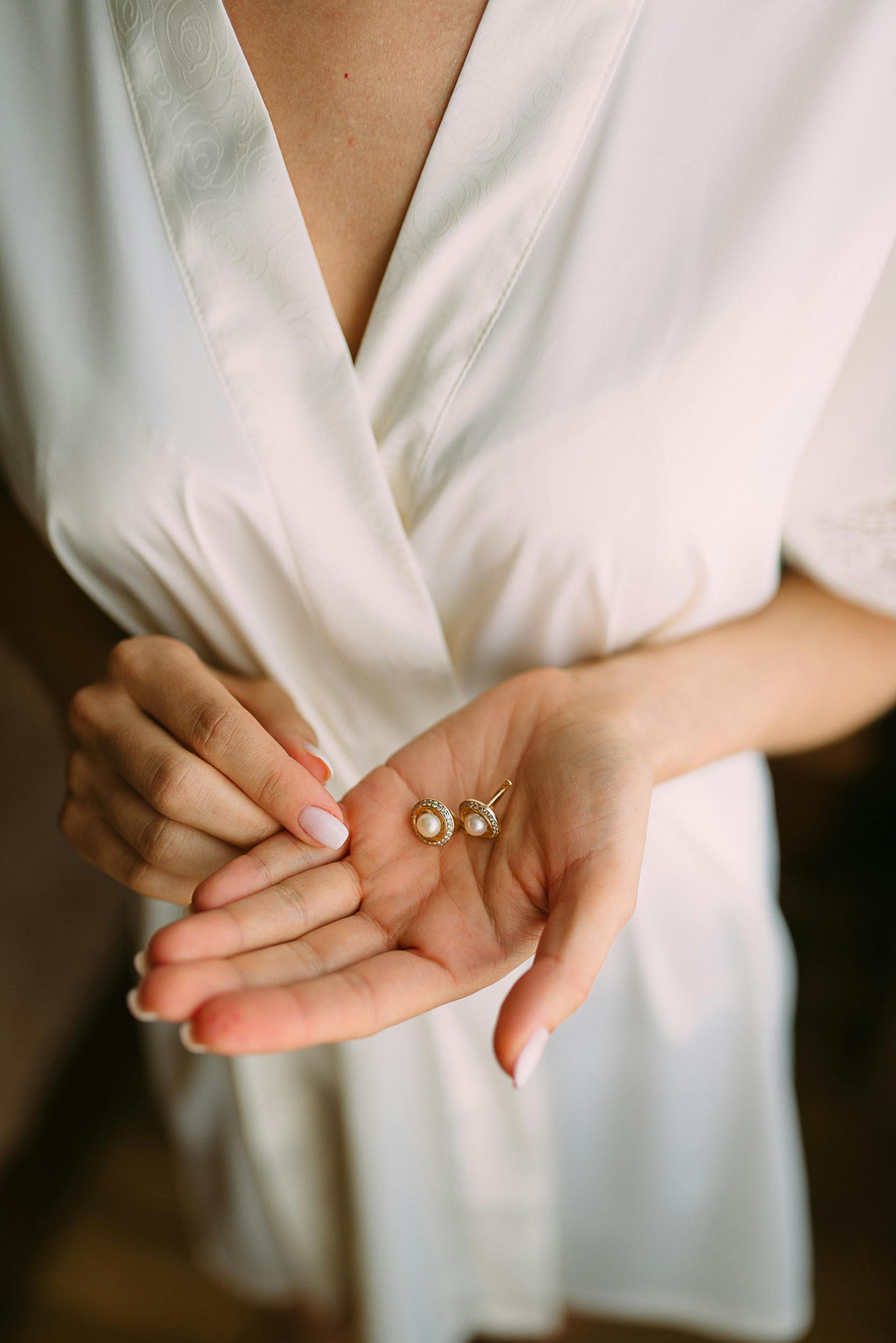 Pair of Gold-colored-and-white Pearl Stud Earrings in Woman's Palm ...