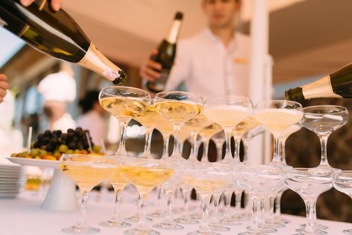 Champagne poured into a tower of coupe glasses at a reception — photo by Dmitry Zvolskiy on Pexels