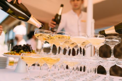 Free Champagne being elegantly poured into glasses at a festive celebration outdoors. Stock Photo