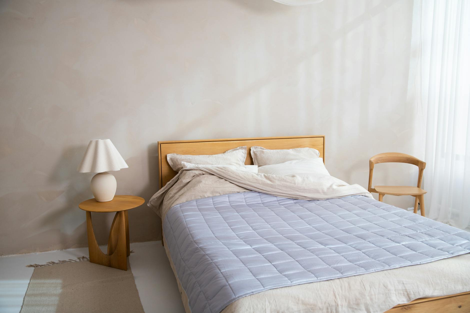 https://www.pexels.com/photo/a-bed-with-a-blue-blanket-and-wooden-headboard-17219738/