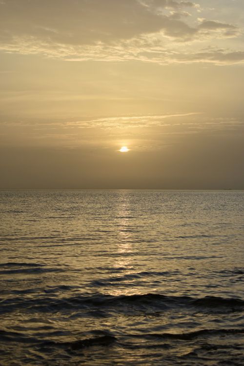 Free Peaceful sunset with a golden sky reflecting over a tranquil sea view. Stock Photo