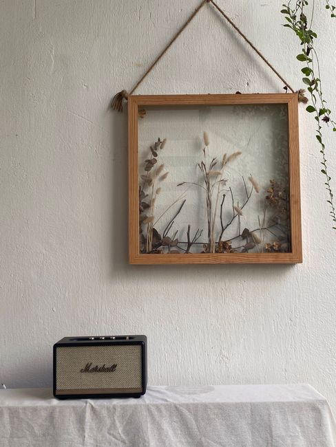 Elegant vintage-style room with botanical frame and radio on white background.