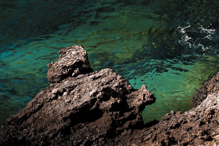 Close Up Of Sunlit Rock Near Water