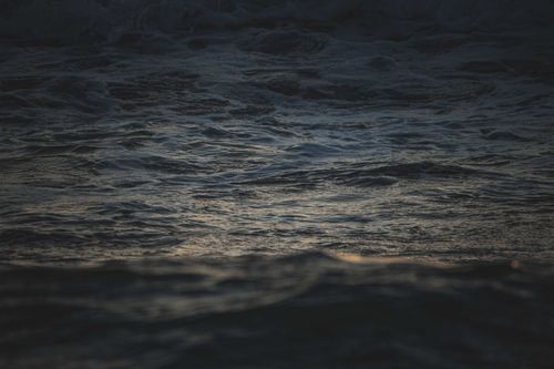 Free Close-up of dark ocean waves with a subtle blue tone, captured during twilight. Stock Photo