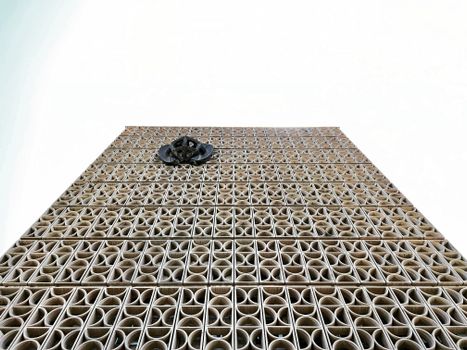 A low angle shot of a building with a unique geometric facade and intricate patterns.