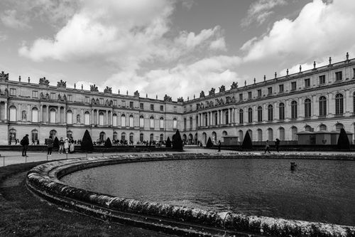 Free Stunning black and white photo of the Palace of Versailles showcasing architectural grandeur and historical significance. Stock Photo