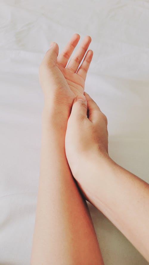 Man and Woman Touching Hands on a Bed