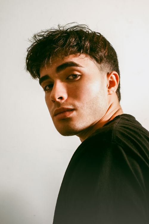 Free Close-up portrait of a young man with bushy eyebrows and bangs, wearing a black shirt. Stock Photo