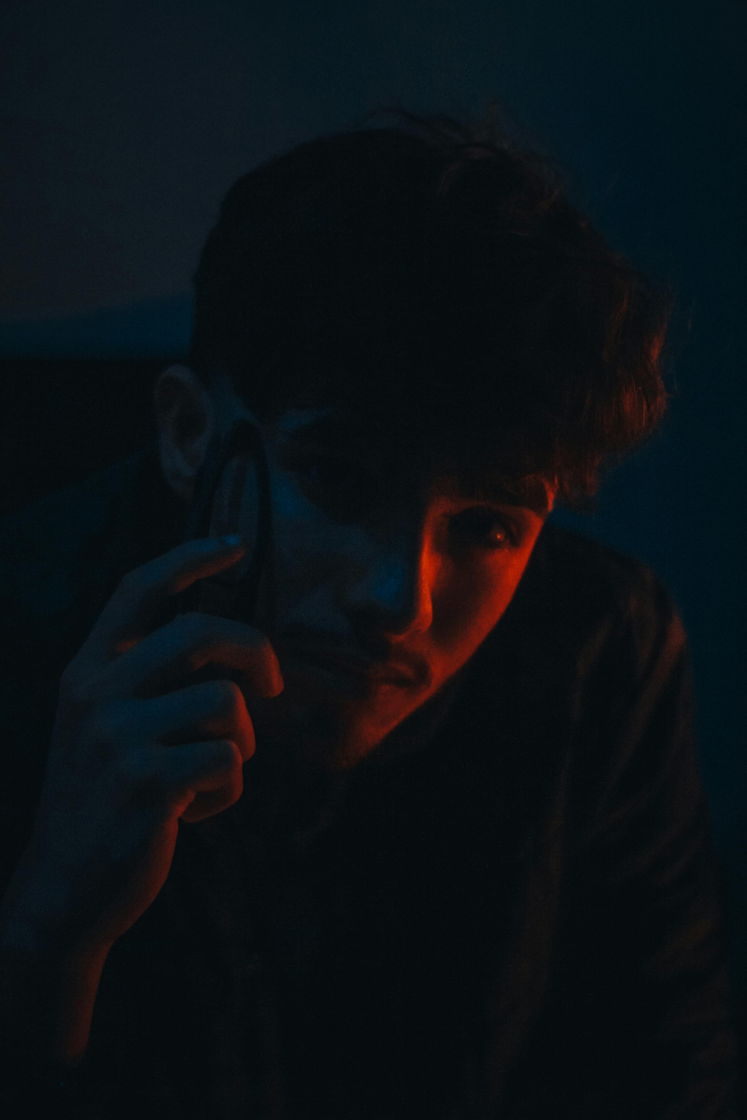 bezplatná Červené Světlo Nad Mužskou Tváří Ve Tmě Základová fotografie