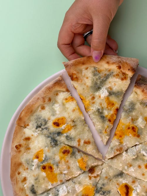 Hand Holding Pizza with Cheese