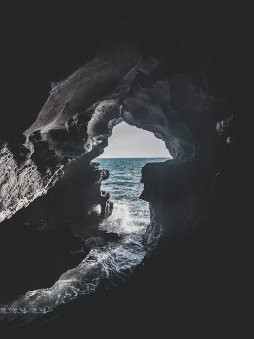 Free Gray Cave Near Body of Water Stock Photo