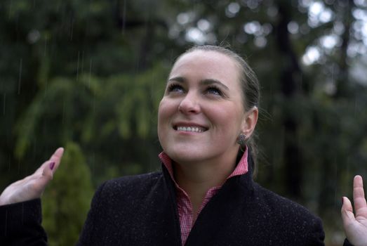 Young Woman Standing in the Rain and Smiling 