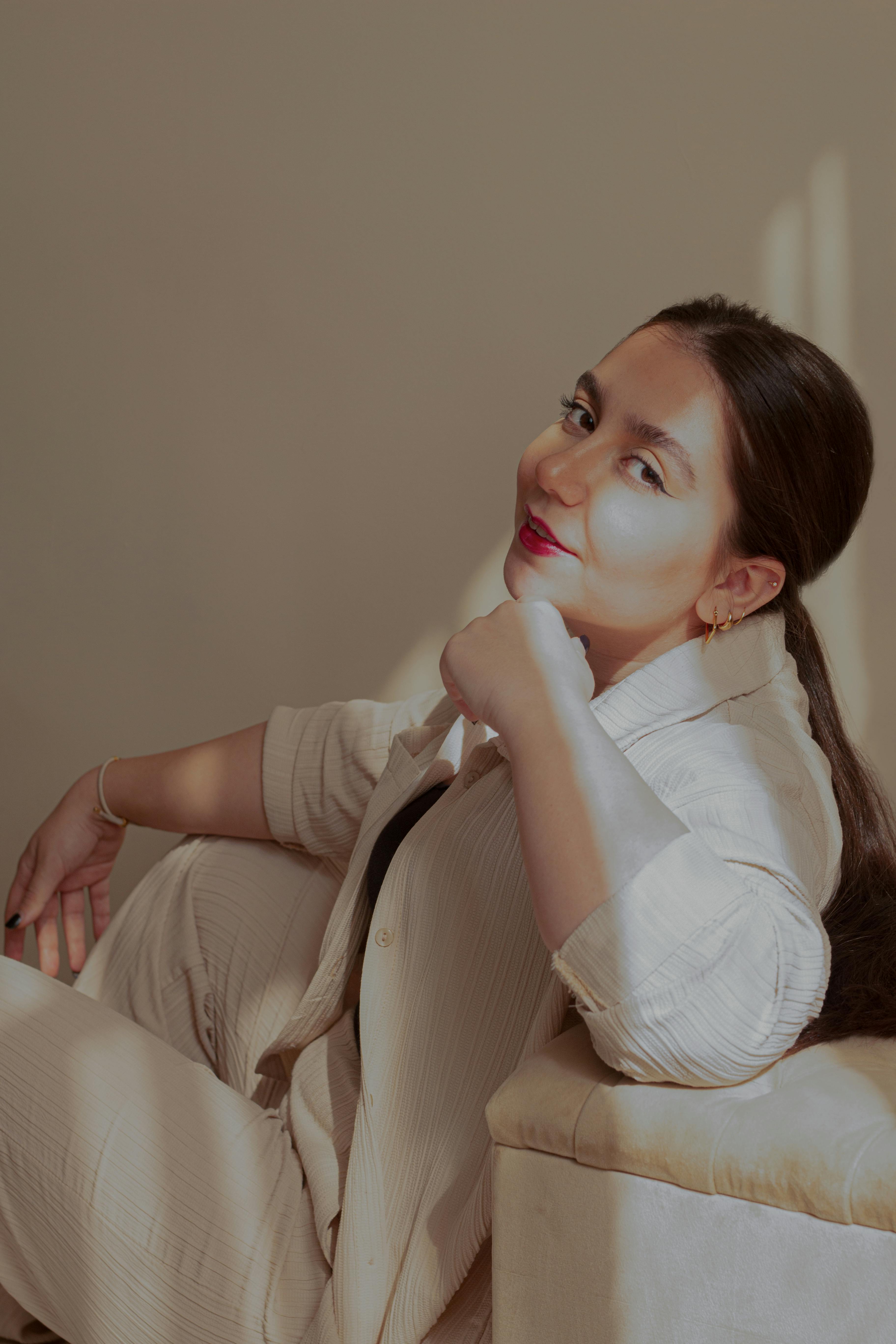 A stylish woman in a light-filled room displaying elegance and allure.