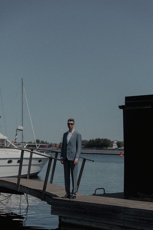 Man in a Suit Standing on a Wooden Pier in the Port 