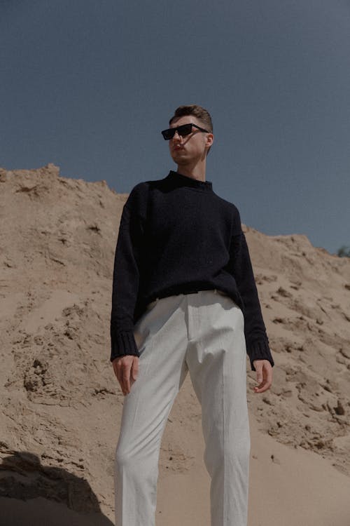 Foto profissional grátis de areia, calça branca, camisola preta