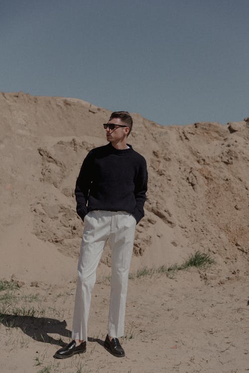 Man Posing in Black Clothes near Sunlit Rock