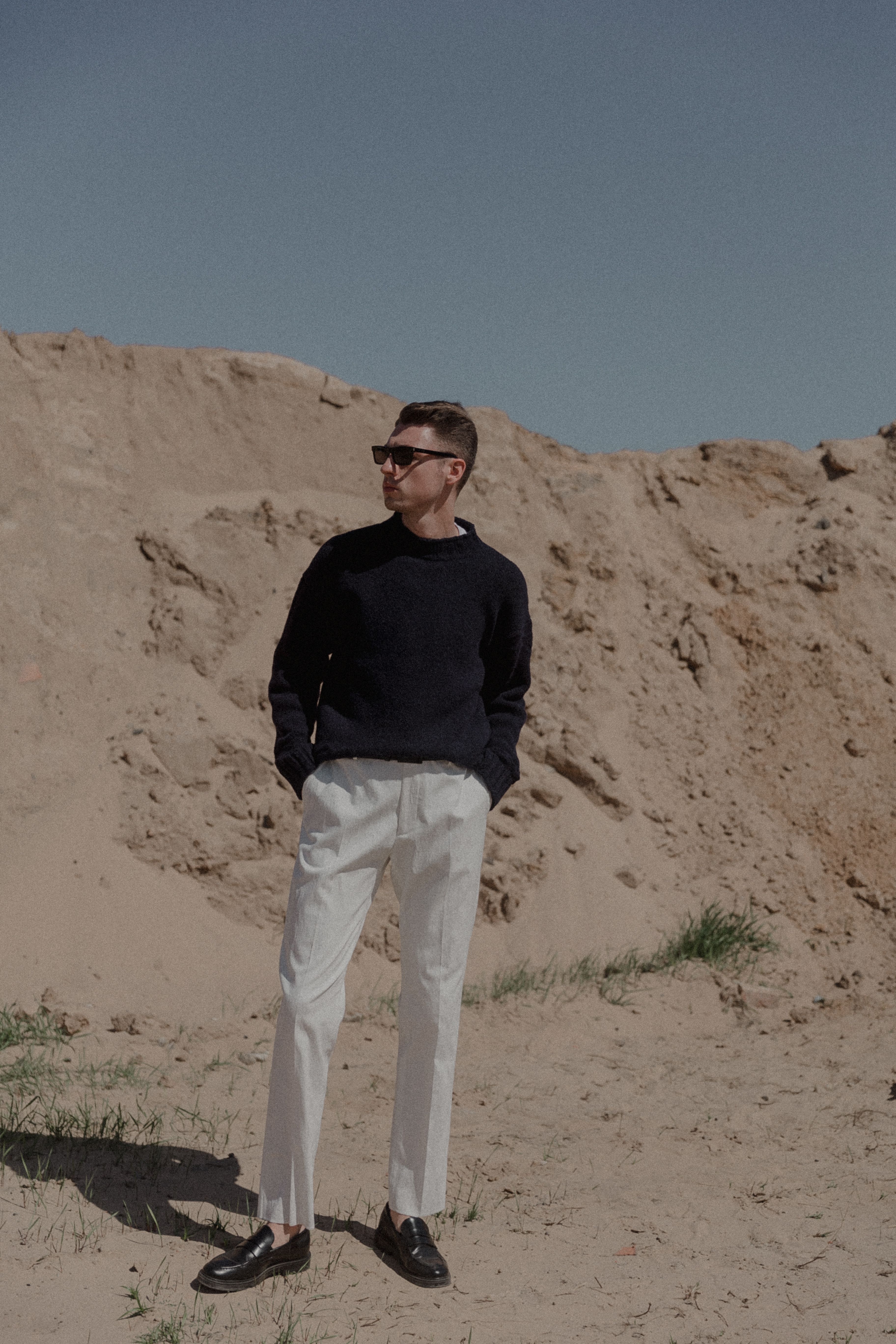 Man Posing in Black Clothes near Sunlit Rock · Free Stock Photo