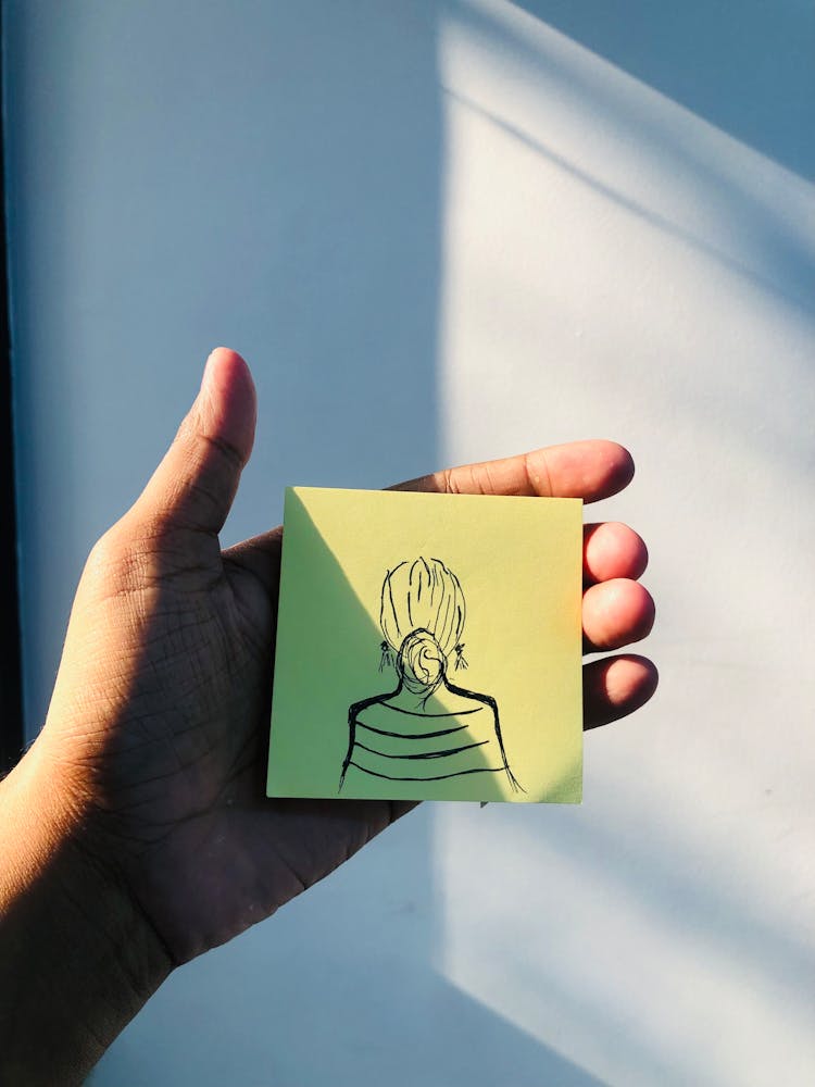 Hand Holding Woman Drawing On Sticky Note