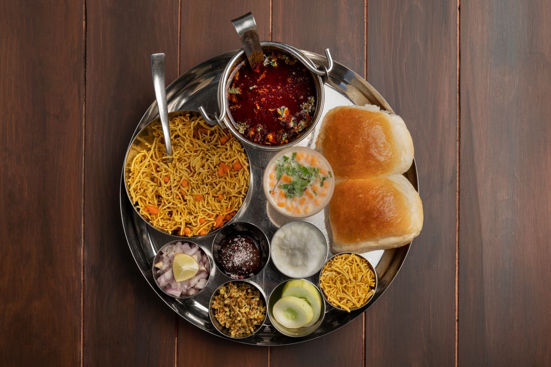 Gujarat's Vegetarian Food Heritage: Why It Leads India 1 Overhead view of a traditional Indian thali with colourful vegetarian curries and accompaniments on a steel plate