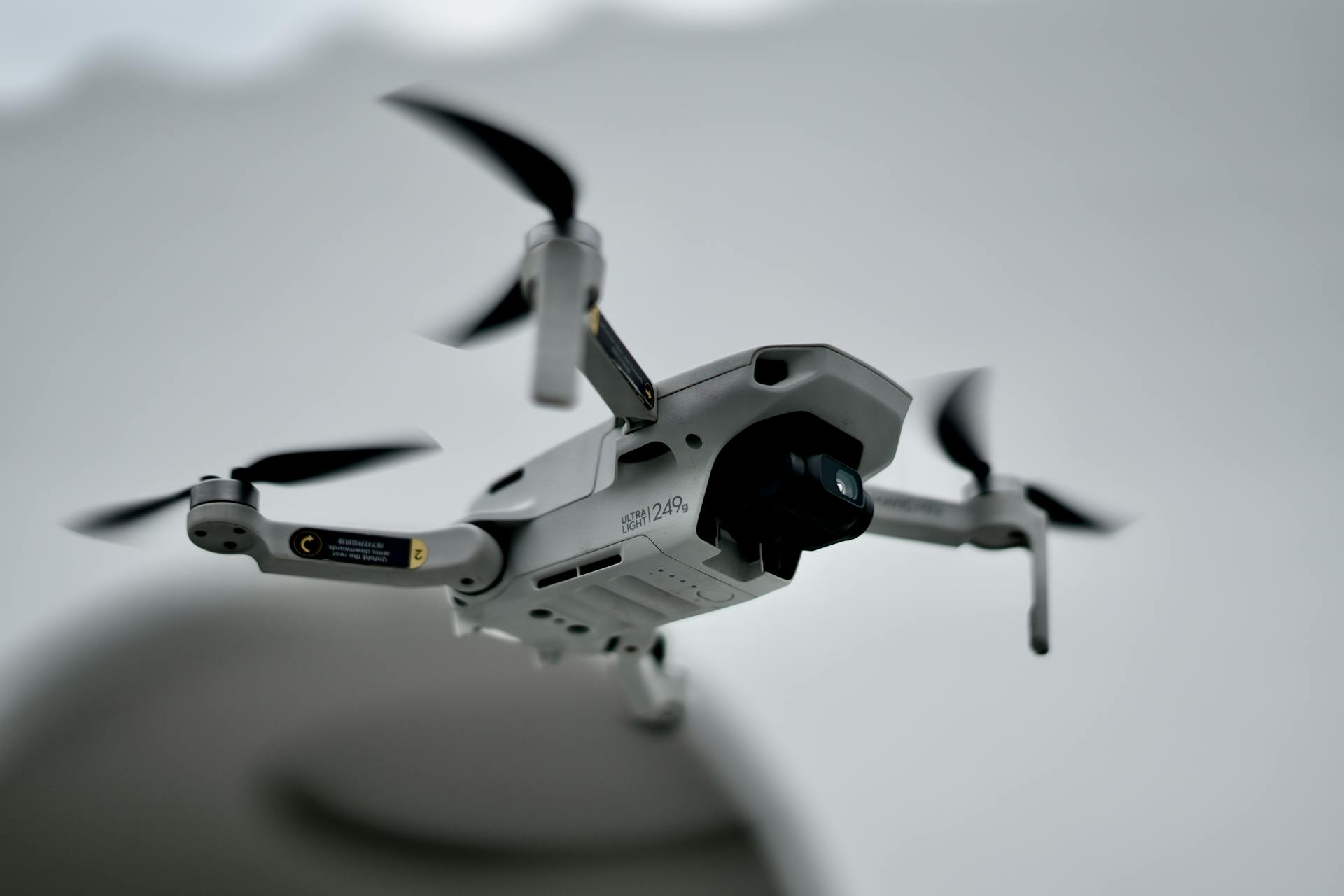 Detailed close-up image of a drone hovering in mid-air with a blurred background.