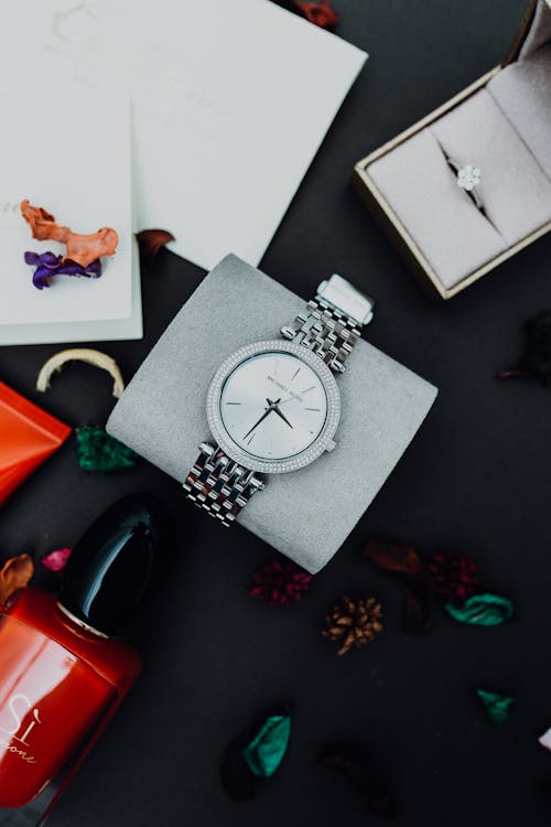 Top View of a Wristwatch, Ring and a Red Nail Polish 