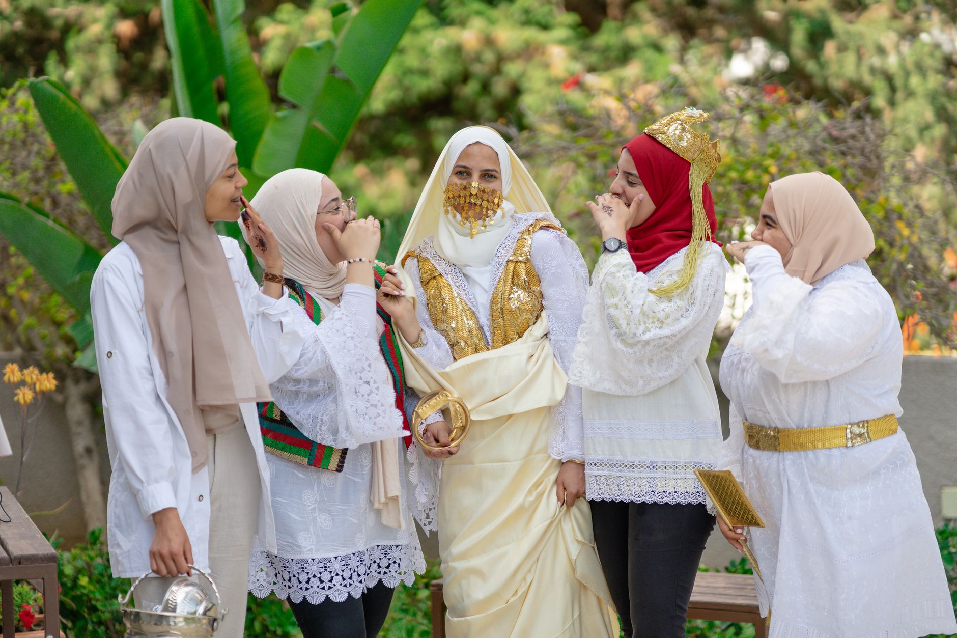 A group of smiling women in traditional attire celebrating outdoors in Nabeul, Tunisia.